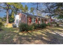 Brick ranch house with a red door and well-manicured lawn at 1302 Richmond Dr., Georgetown, SC 29440