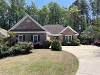 Charming single-story brick home with mature landscaping and a spacious driveway at 35 Dornoch Dr., Pawleys Island, SC 29585