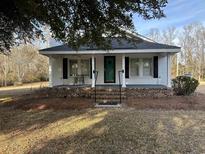 White brick ranch house with covered porch, steps, and a landscaped yard at 402 S S. Firestation Rd., Johnsonville, SC 29555