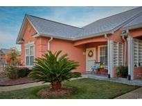 Charming coral exterior with welcoming porch and nicely landscaped yard at 4648 Lightkeepers Way # 39-A, Little River, SC 29566