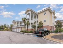 Exterior of 3-story condo building with parking and landscaping at 4872 Dahila Ct. # 301, Myrtle Beach, SC 29577