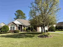 Brick house with a two-car garage and well-manicured lawn at 635 Bucks Trail, Longs, SC 29568
