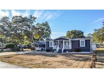 Gray house with white trim, front porch, and landscaping at 1005 S Marlin Circle, Murrells Inlet, SC 29576