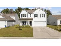 Two-story white house with a two-car garage and landscaped yard at 2871 Ellesmere Circle, Myrtle Beach, SC 29579