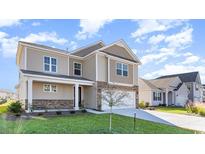 Two-story house with beige siding, stone accents, and a two-car garage at 382 Glacier Way, Conway, SC 29526