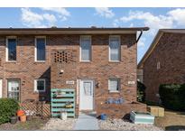 Brick townhouse exterior with landscaping and a charming front entrance at 405 Garden Dr. # 106A, Surfside Beach, SC 29575