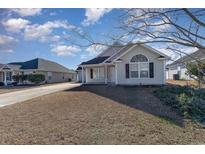 Tan house with a gray roof, a garage, and a well-maintained lawn at 469 Wallingford Circle, Myrtle Beach, SC 29588