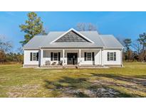 White farmhouse exterior with gray metal roof and front porch at 5300 Juniper Bay Rd., Conway, SC 29527