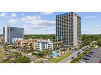 Aerial view of coastal high-rise building with pool and parking at 5523 N Ocean Blvd. # 1601, Myrtle Beach, SC 29577