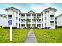 Three-story building with multiple balconies and a manicured lawn at 557 White River Dr. # 12A, Myrtle Beach, SC 29579