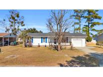 White house with blue accents, wooden porch, and a spacious yard at 789 University Forest Circle, Conway, SC 29526