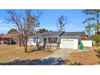 Charming single-story home with a front porch and attached garage on a sunny day at 789 University Forest Circle, Conway, SC 29526