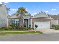 Curb appeal abounds with this charming home, showcasing stone and shingle accents, a welcoming porch, and a two-car garage at 912 Lorenzo Dr., North Myrtle Beach, SC 29582