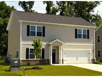 Charming two-story home featuring a well-maintained lawn and attached two-car garage at 112 Lakota Loop, Longs, SC 29568