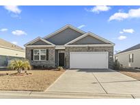 Brick and gray siding house with a two-car garage and landscaping at 1164 Maxwell Dr., Little River, SC 29566