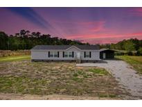 Charming single-story home with grey siding, black shutters, and a well-maintained gravel driveway at 122 Willie Mays Pl., Aynor, SC 29511