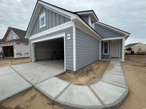 New construction home showing the grey siding, white trim, and attached garage at 1245 Lady Bird Way, North Myrtle Beach, SC 29582