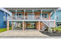 Charming beach cottage with elevated design, spacious porch, and parking underneath at 130 Easy St., Murrells Inlet, SC 29576