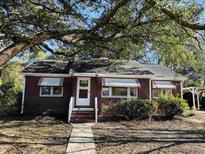 Brick ranch house with carport, mature trees, and landscaped yard at 1916 Calhoun St., Georgetown, SC 29440