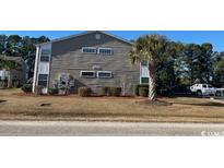 Two-story building exterior, featuring gray siding and landscaping at 1925 Bent Grass Dr. # B, Surfside Beach, SC 29575