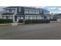 Gray townhouses with white shutters, landscaping, and a paved driveway at 3700 Golf Colony Lane # 2D, Little River, SC 29566