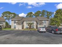 Tan colored building with parking lot and landscaping at 4490 Little River Inn Ln. # 2203, Little River, SC 29566