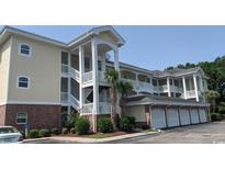 Three-story building with garages and palm trees at 4881 Dahlia Ct. # 101, Myrtle Beach, SC 29577