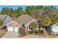 Brick house with two-car garage, palm trees, and manicured landscaping at 5808 Bridlewood Rd., North Myrtle Beach, SC 29582