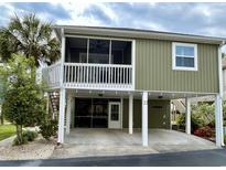 Charming raised beach home with a carport, a screened porch, and a landscaped yard at 820 9Th Ave. S, North Myrtle Beach, SC 29582