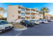 Inviting condo complex with multiple levels, parking, and a lush palm tree in a sunny location at 1100 Possum Trot Rd. # H234, North Myrtle Beach, SC 29582