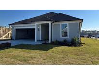 New construction home featuring a light gray exterior, black roof, and open garage at 1300 Crested Iris Way, North Myrtle Beach, SC 29582
