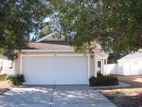 Beige house with white garage door and landscaping at 148 Junco Circle, Longs, SC 29568