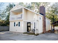 Two-story house with light beige siding, balcony, and a brick chimney at 1807 C Hillside Dr., North Myrtle Beach, SC 29582