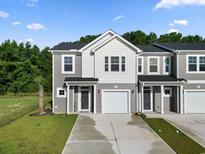 Two-story townhome with gray siding, two-car garage, and a well-manicured lawn at 253 Sandridgebury Dr. # 59, Little River, SC 29566