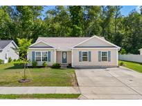 Beige house with teal shutters, driveway, and grassy yard at 3348 Merganser Dr., Conway, SC 29527