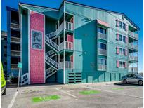 Seawatch VII building exterior, teal and pink, with parking and ocean view at 400 N Waccamaw Dr. # 304, Garden City Beach, SC 29576