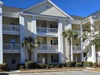Three-story building with light-colored siding, balconies, and palm trees at 601 Hillside Ave. N # 1623, North Myrtle Beach, SC 29582