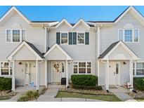 Three-unit townhome building, light taupe siding, green shutters, and landscaping at 618 3Rd Ave. S # 4D, North Myrtle Beach, SC 29582