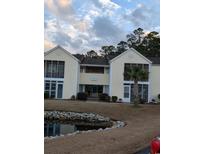 Attractive exterior of a two-story building with pond at 8885 Grove Park Dr. # F, Surfside Beach, SC 29575