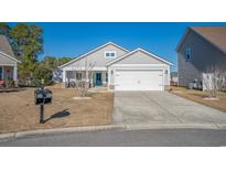 Charming single-story home featuring a two-car garage, blue front door, and well-maintained landscaping at 1141 Bethpage Dr., Myrtle Beach, SC 29579