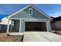 Attached two-car garage with a carriage door design and a concrete driveway at 1252 Lady Bird Way, North Myrtle Beach, SC 29582