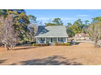 Charming single-story home featuring a welcoming front porch and lush green trees at 16 Johnstone Ln., Georgetown, SC 29440