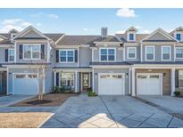 Gray siding three-story townhome with two-car garage and landscaping at 2404 Thoroughfare Dr. # 2404, North Myrtle Beach, SC 29582