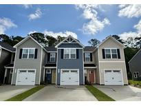 Charming new construction townhomes with individual garages, varied siding colors, and inviting curb appeal on a sunny day at 261 Christiana Ln. # B, Myrtle Beach, SC 29579
