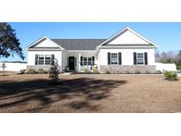 White farmhouse exterior with brick accents and a well-manicured lawn at 262 Ole Maple St., Loris, SC 29569