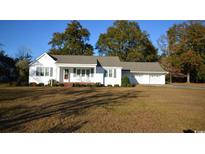 White house with gray trim, attached garage, and spacious lawn at 4819 Walnut St., Loris, SC 29569