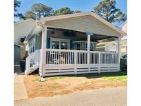 Quaint beach cottage with covered porch and American flag at 6001-1655 South Kings Hwy., Myrtle Beach, SC 29575