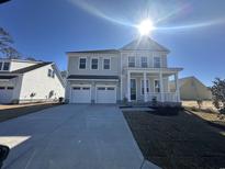 Charming two-story home with a welcoming front porch, two-car garage, and fresh landscaping at 6525 Berg St., Murrells Inlet, SC 29576