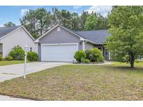Charming single-story home with a two-car garage, lush landscaping, and well-manicured lawn at 184 Retreat Pl., Little River, SC 29566