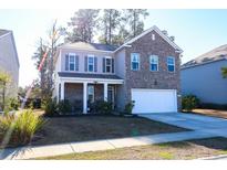 Two-story brick home with a welcoming front porch and attached garage at 2998 Skylar Dr., Myrtle Beach, SC 29577